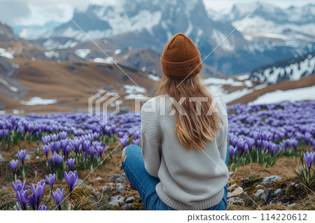 Young Woman Contemplating Mountain View Among Purple Crocuses 114220612