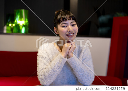 Smiling young woman looking at the camera, night, home image 114221259