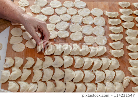 Dumpling. Woman hands are making a damp dumpling. Dumpling. Woman hands are making a damp dumpling. 114221547