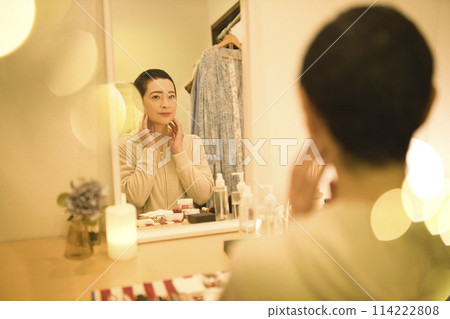 A middle-aged woman who does her nighttime skin care routine while worrying about rough skin A middle-aged woman who does her nighttime skin care routine while worrying about rough skin 114222808