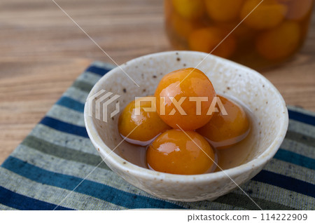 Golden kumquat candied in a bowl on a wooden table 114222909