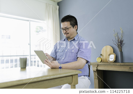 一個日本大男人在家使用平板電腦 一個日本大男人在家使用平板電腦 114225718