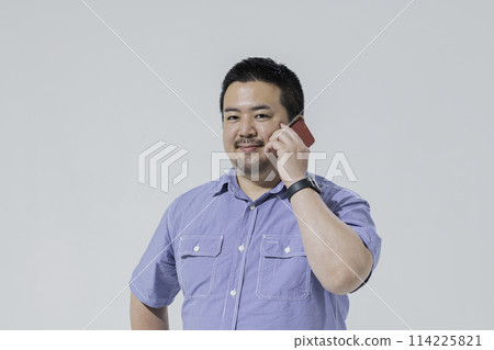一個大個子的日本男人用智慧型手機打電話 114225821