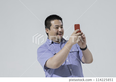 一個大個子的日本男人用智慧型手機拍照 114225851