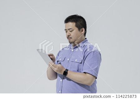 一個大個子的日本男人使用平板電腦設備 114225873