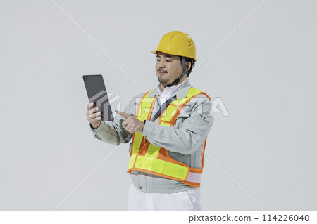 穿著工作服的男人看著平板電腦設備 穿著工作服的男人看著平板電腦設備 114226040