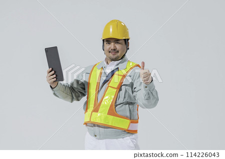 一個穿著工作服的男人拿著平板電腦終端機豎起大拇指 一個穿著工作服的男人拿著平板電腦終端機豎起大拇指 114226043
