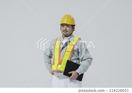 一個穿著工作服和一台電腦的男人 114226051