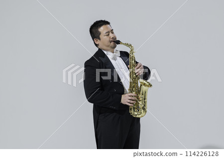 A large Japanese man playing the saxophone 114226128