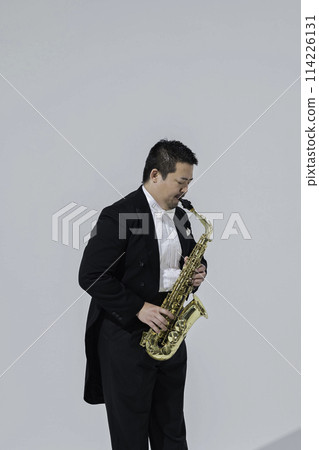 A large Japanese man playing the saxophone A large Japanese man playing the saxophone 114226131