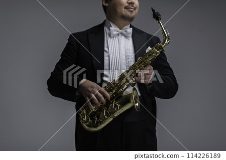 A large Japanese man playing the saxophone A large Japanese man playing the saxophone 114226189