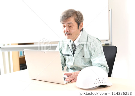 A middle-aged male worker working on a computer A middle-aged male worker working on a computer 114226238