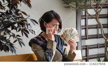 A woman who is depressed when she sees money 114227656