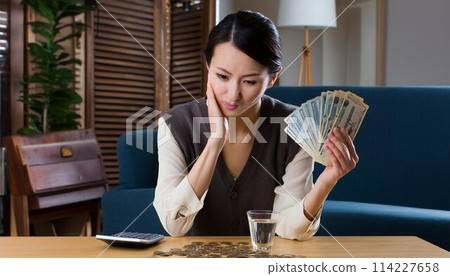 A woman who is depressed when she sees money 114227658