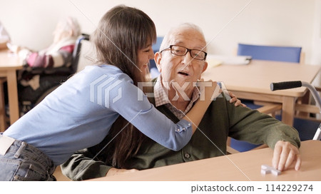 Granddaughter looking at her grandfather with a happy smile Granddaughter looking at her grandfather with a happy smile 114229274