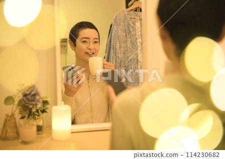 中年婦女一邊放鬆一邊看智慧型手機，一邊看咖啡 114230682