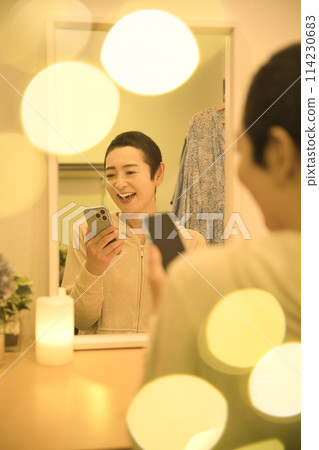 中年婦女一邊放鬆一邊看智慧型手機,一邊看咖啡 中年婦女一邊放鬆一邊看智慧型手機,一邊看咖啡 114230683