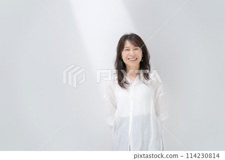 Middle-aged woman in a white shirt Middle-aged woman in a white shirt 114230814