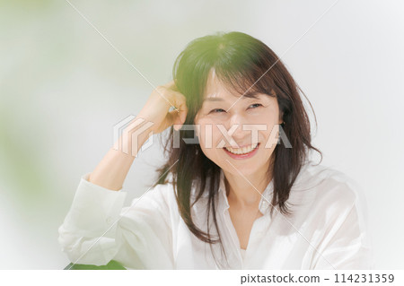 Middle-aged woman in a white shirt Middle-aged woman in a white shirt 114231359