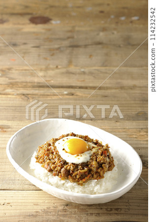Keema curry topped with egg yolk and burnt cheese Keema curry topped with egg yolk and burnt cheese 114232542