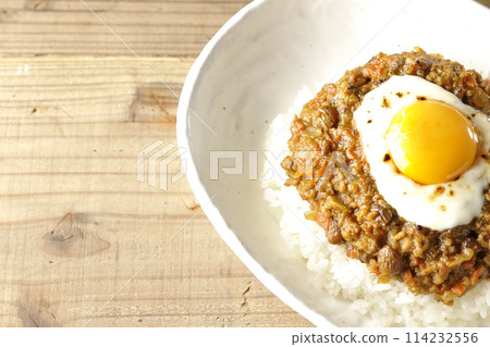 Keema curry topped with egg yolk and burnt cheese Keema curry topped with egg yolk and burnt cheese 114232556