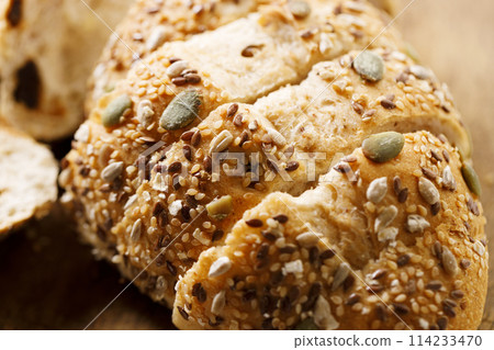 Fresh baked bread and sliced on wooden table. 114233470