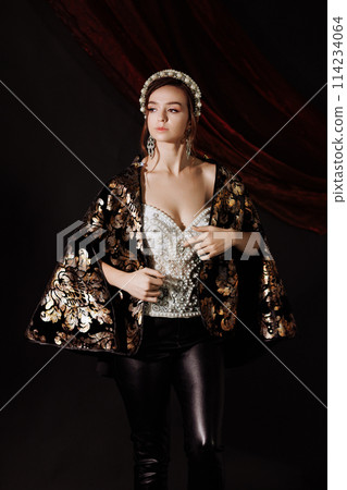 A woman in a Renaissance dress in a gold picture frame on a red background. A woman in a Renaissance dress in a gold picture frame on a red background. 114234064