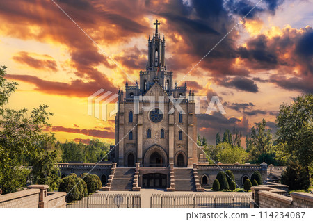 Cathedral of Sacred Heart of Jesus in Tashkent in Uzbekistan. Facade of ancient Church on background of cloudy dramatic sky at sunrise in summer 114234087