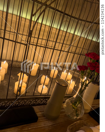 Carnation flowers in a vase and candles on a table in a restaurant 114234136