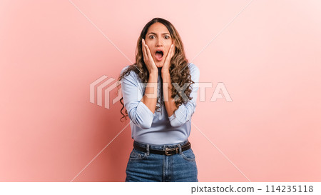 Surprised woman gesturing with mouth open looking at camera 114235118