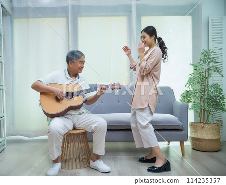 A man playing a folk guitar and a woman singing and clapping 1 114235357