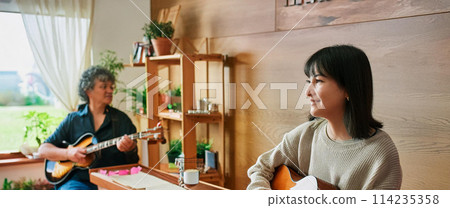 Woman playing folk guitar_Man playing electric guitar 1 114235358