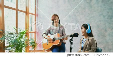 一位彈民謠吉他的女士和一位女歌手高喊 1 一位彈民謠吉他的女士和一位女歌手高喊 1 114235359