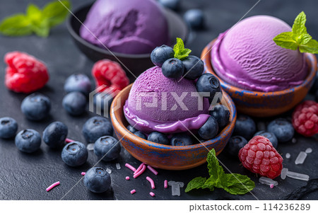 Close up of a single scoop of purple ice cream in a cone. Close up of a single scoop of purple ice cream in a cone. 114236289