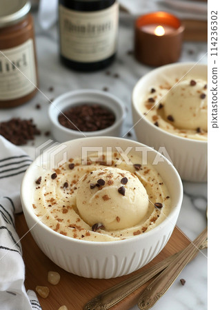 A scoop of vanilla ice cream topped with chocolate chips. 114236302