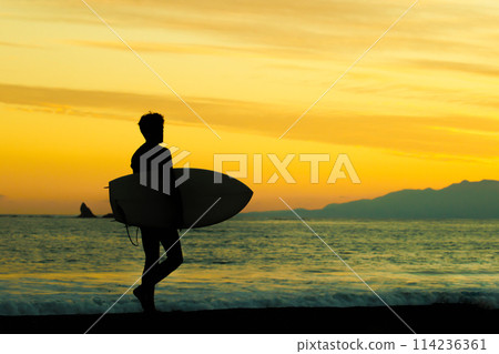 Eboshi Rock and the silhouette of a surfer on Shonan Coast 114236361