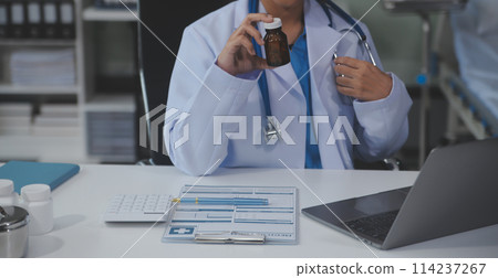 Cropped view of doctor in white coat holding bottle medication, prescribing pills to sick patient via online consultation. Family therapist recommend quality medicines. Healthcare, treatment concept Cropped view of doctor in white coat holding bottle medication, prescribing pills to sick patient via online consultation. Family therapist recommend quality medicines. Healthcare, treatment concept 114237267