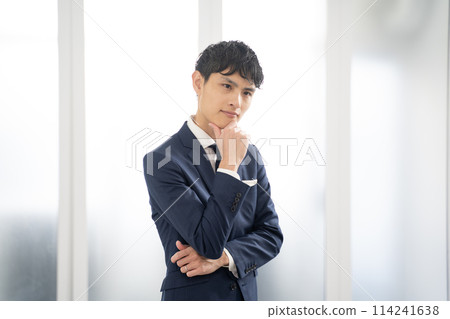 一位憂心忡忡的男性商人雙臂交叉 一位憂心忡忡的男性商人雙臂交叉 114241638