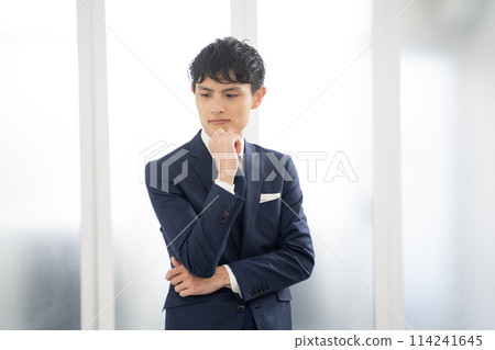 A worried male businessman with his arms folded 114241645