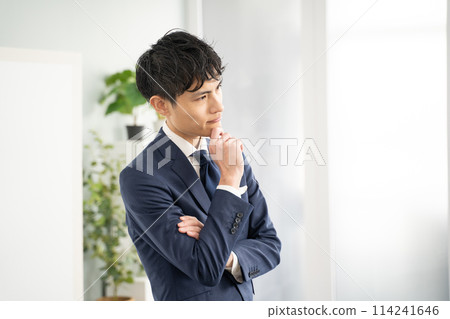 A worried male businessman with his arms folded 114241646