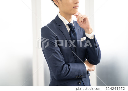 A worried male businessman with his arms folded A worried male businessman with his arms folded 114241652