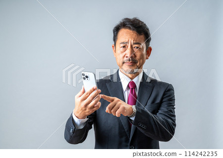 A middle-aged man using a smartphone. 114242235