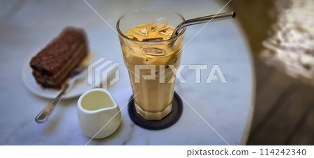 Fresh iced coffee in glass with frothy cream for your design, Food concept in style, copy space Fresh iced coffee in glass with frothy cream for your design, Food concept in style, copy space 114242340