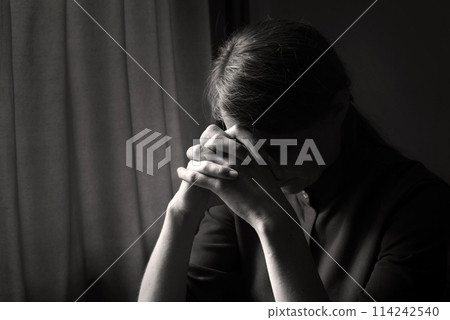 Praying woman at the window 114242540