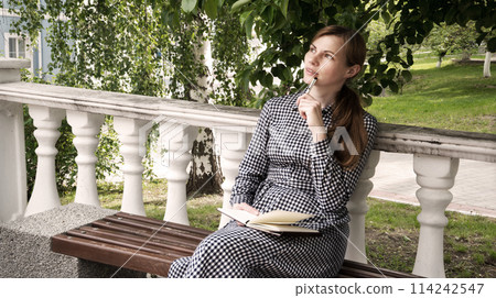 Girl writes in a notebook 114242547