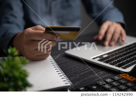 Online Payment Process hands of an individual holding credit card with a laptop for online transactions. Business financial and banking commerce network Online Payment Process hands of an individual holding credit card with a laptop for online transactions. Business financial and banking commerce network 114242990