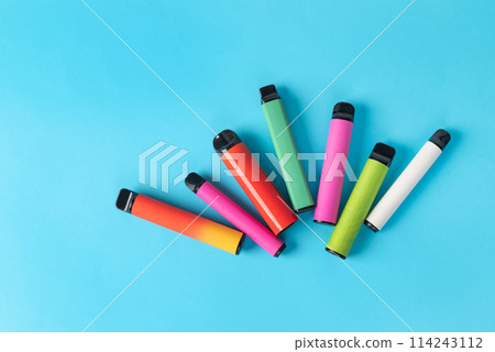 colorful disposable electronic cigarettes on a blue background. The concept of modern smoking colorful disposable electronic cigarettes on a blue background. The concept of modern smoking 114243112