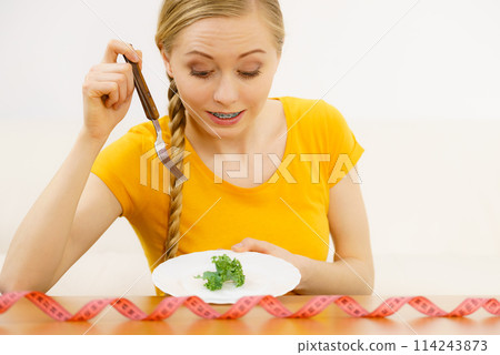 Woman on diet holding plate with lettuce 114243873