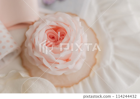 handmade candle in the shape of a flower on a light background, space for text 114244432