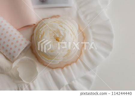 handmade candle in the shape of a flower on a light background, space for text 114244440